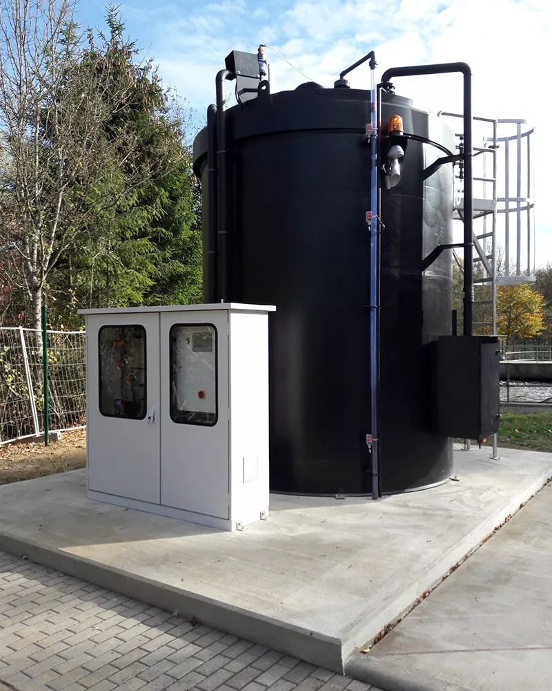 Behälterbau | Silberner Schaltkasten neben einem schwarzen Behälter.