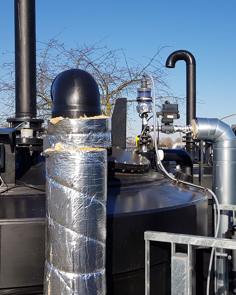 Rohrleitungsbau | Ein imposanter schwarzer Tank, umgeben von verschiedenen Rohren und Leitungen, die seine Funktionalität unterstützen.